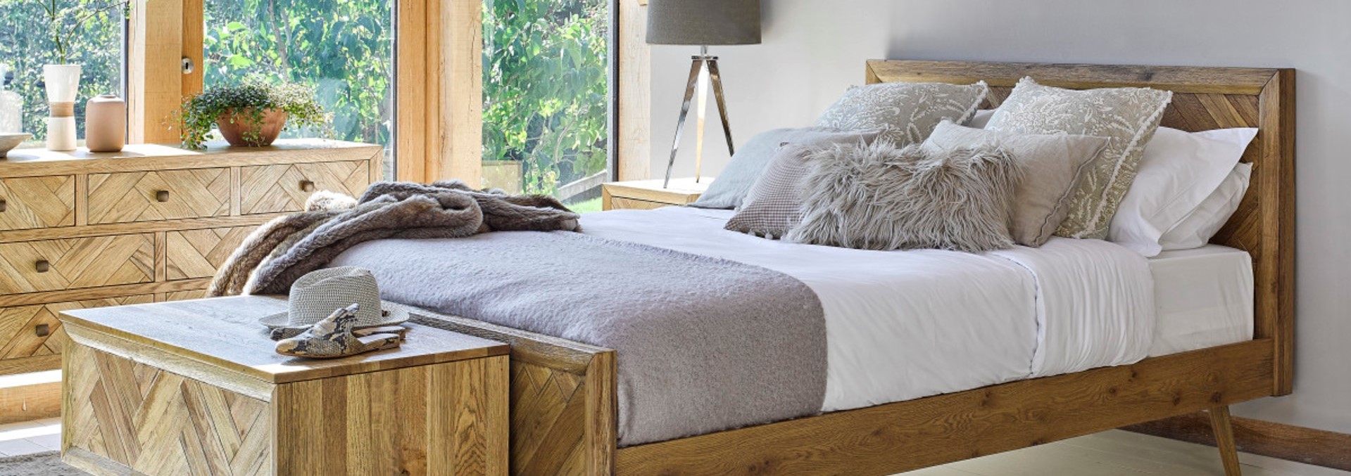 Neutral style bedroom with exposed beams, wood windows and herringbone style oak furniture.